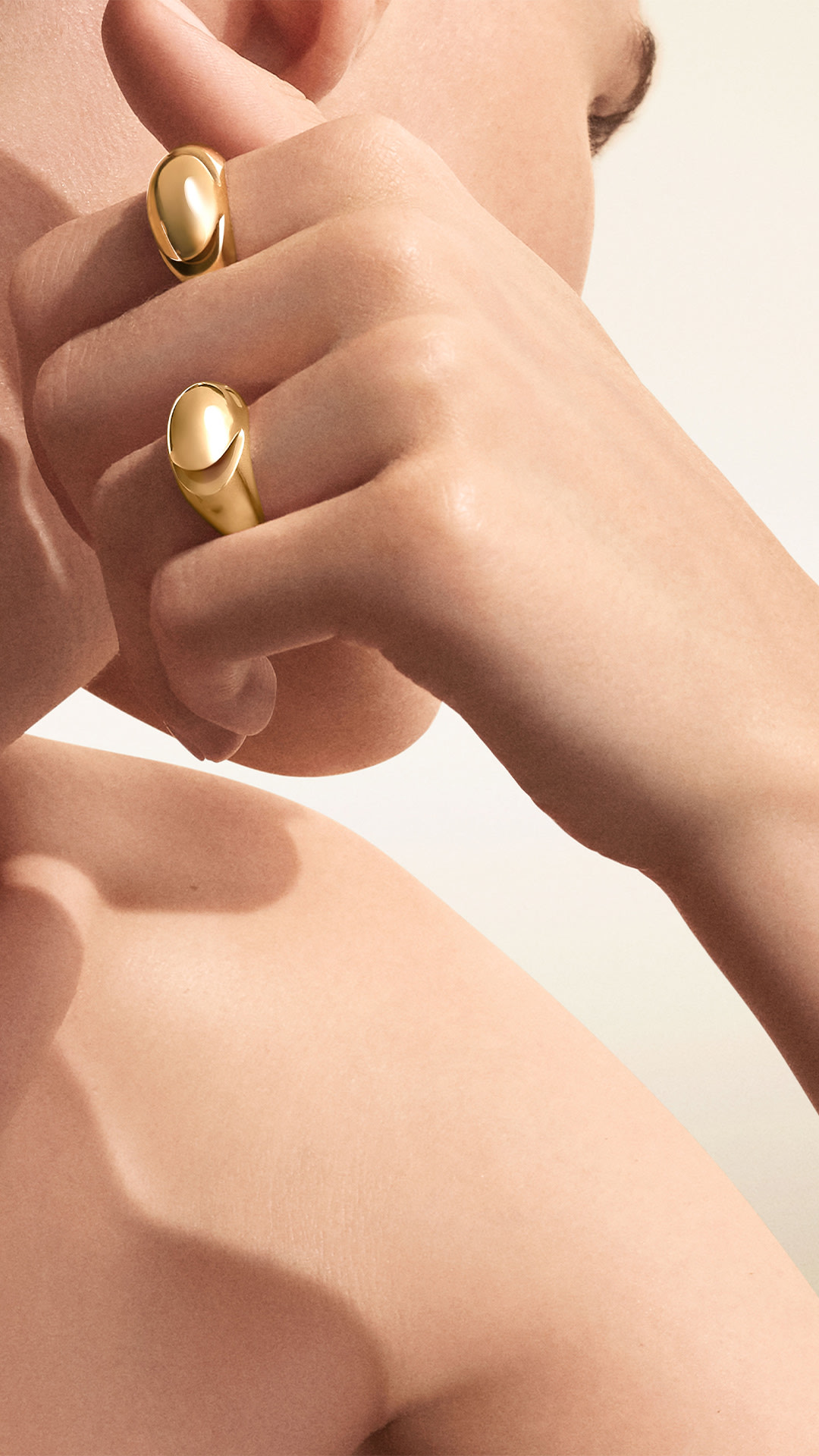 Model wearing Bulgari Cabochon rings in 18 kt rose and yellow gold, close up.