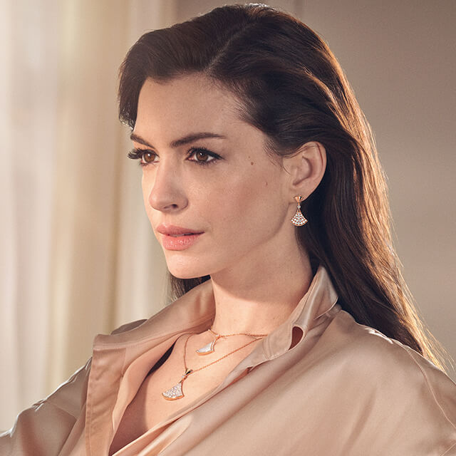 Anne Hathaway wearing rose gold Divas’ Dream earrings and necklaces with a mother-of-pearl insert.