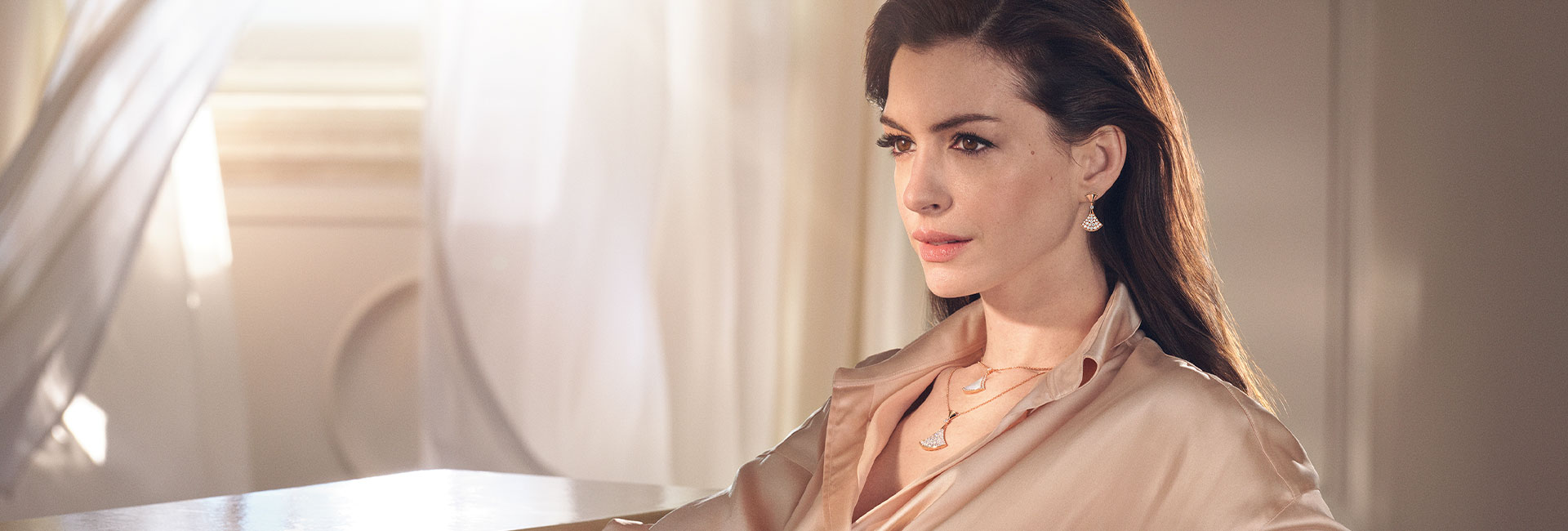 Anne Hathaway wearing Divas' Dream jewellery and Divas' Dream pendant necklaces against a white backdrop.